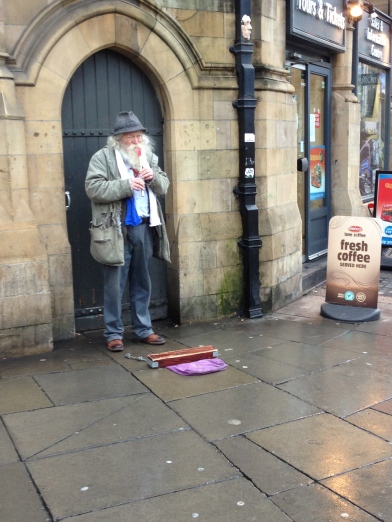A busker plays his tin flute on Dame Street